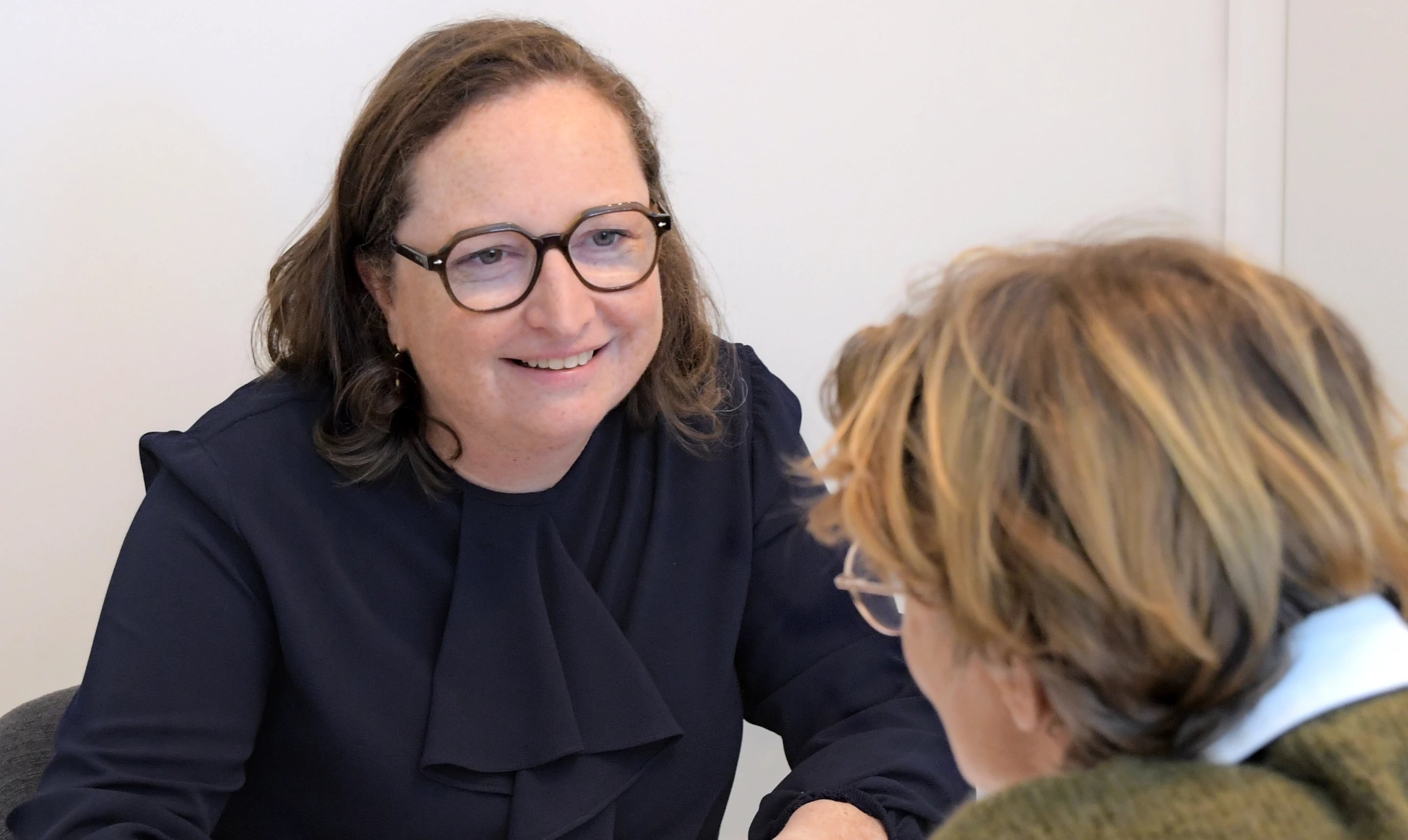 Elfriede Neels lacht tijdens een gesprek aan tafel