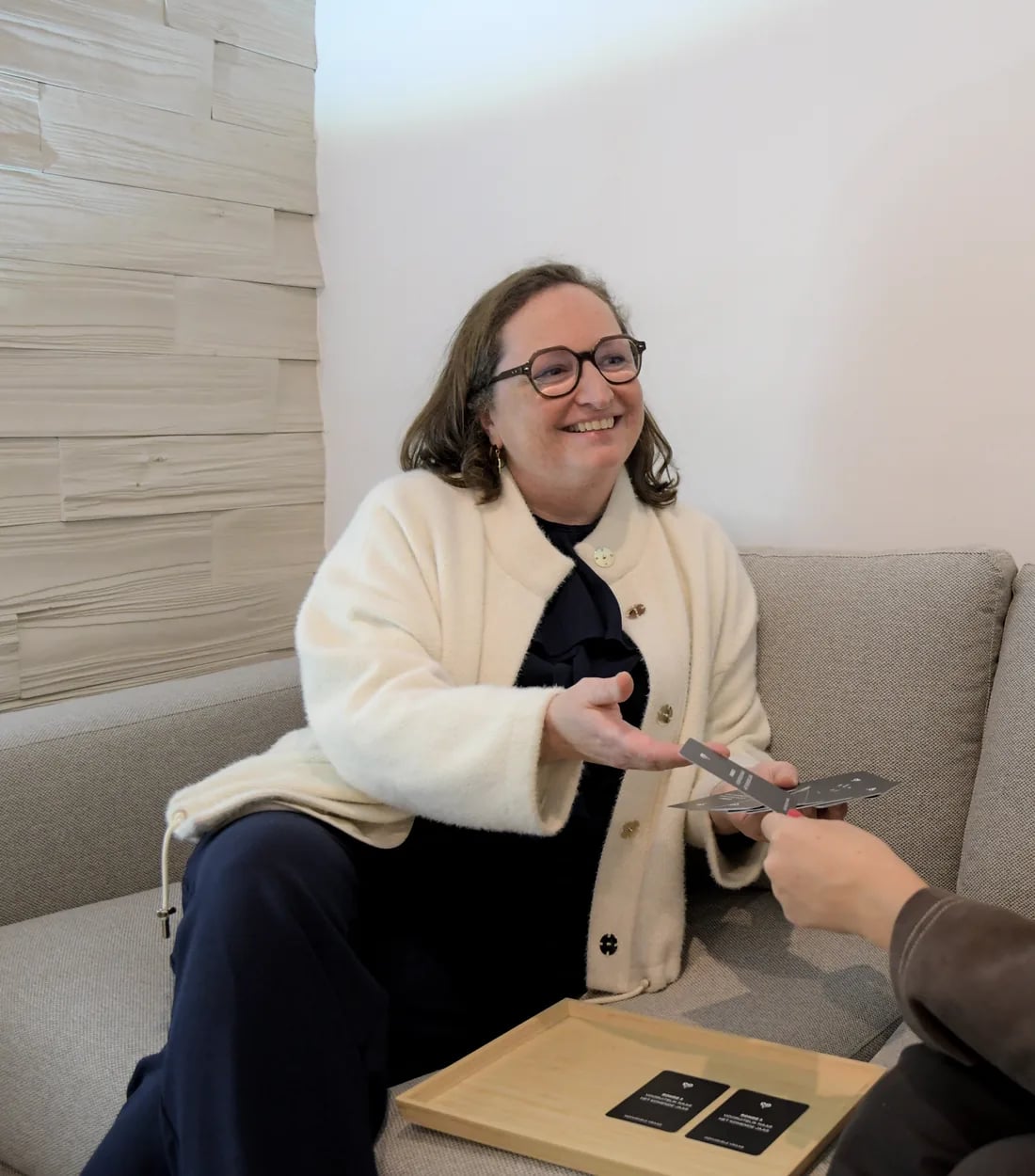 Elfriede lacht in de zetel tijdens een gesprek