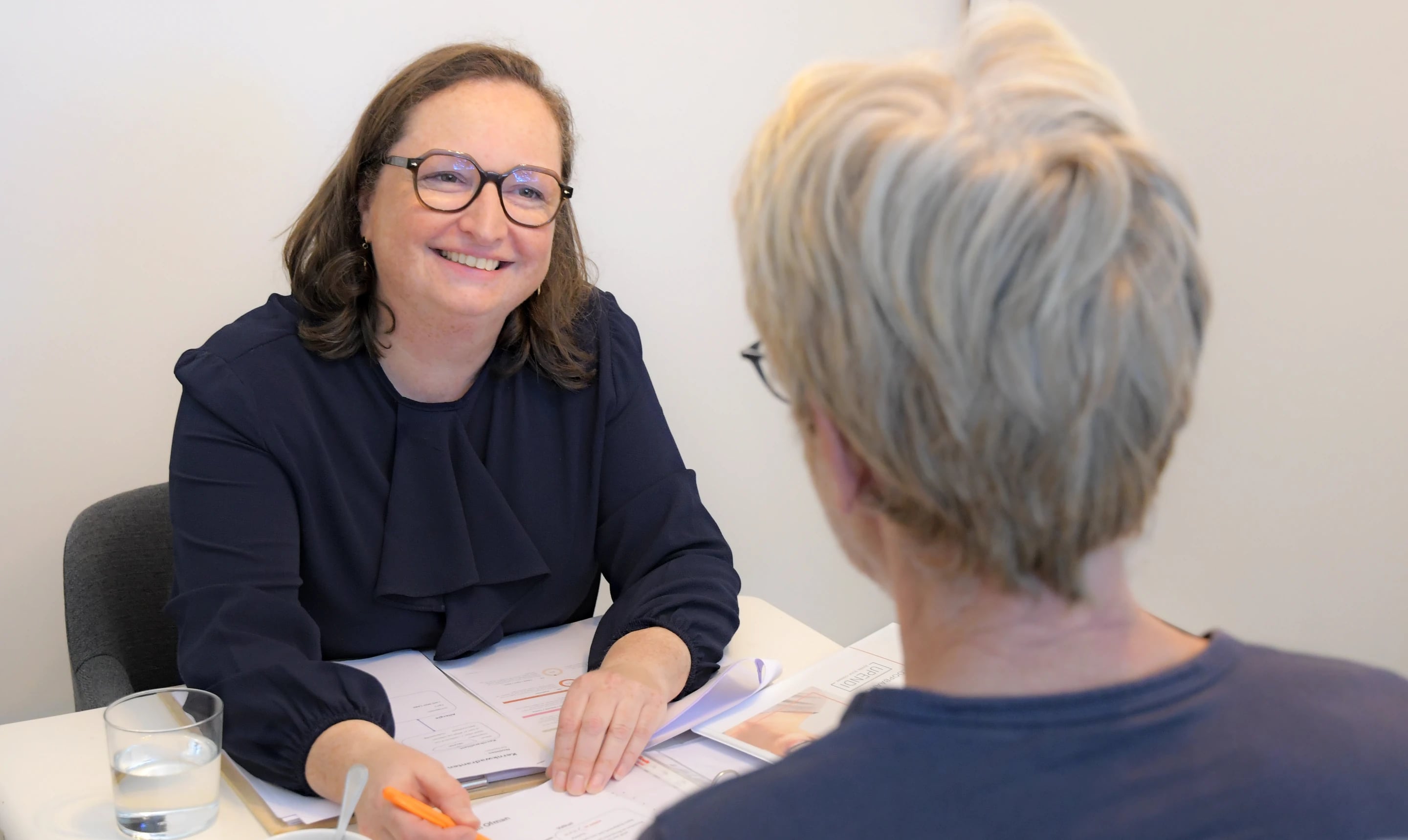 Elfriede Neels in gesprek met een cliënte aan tafel