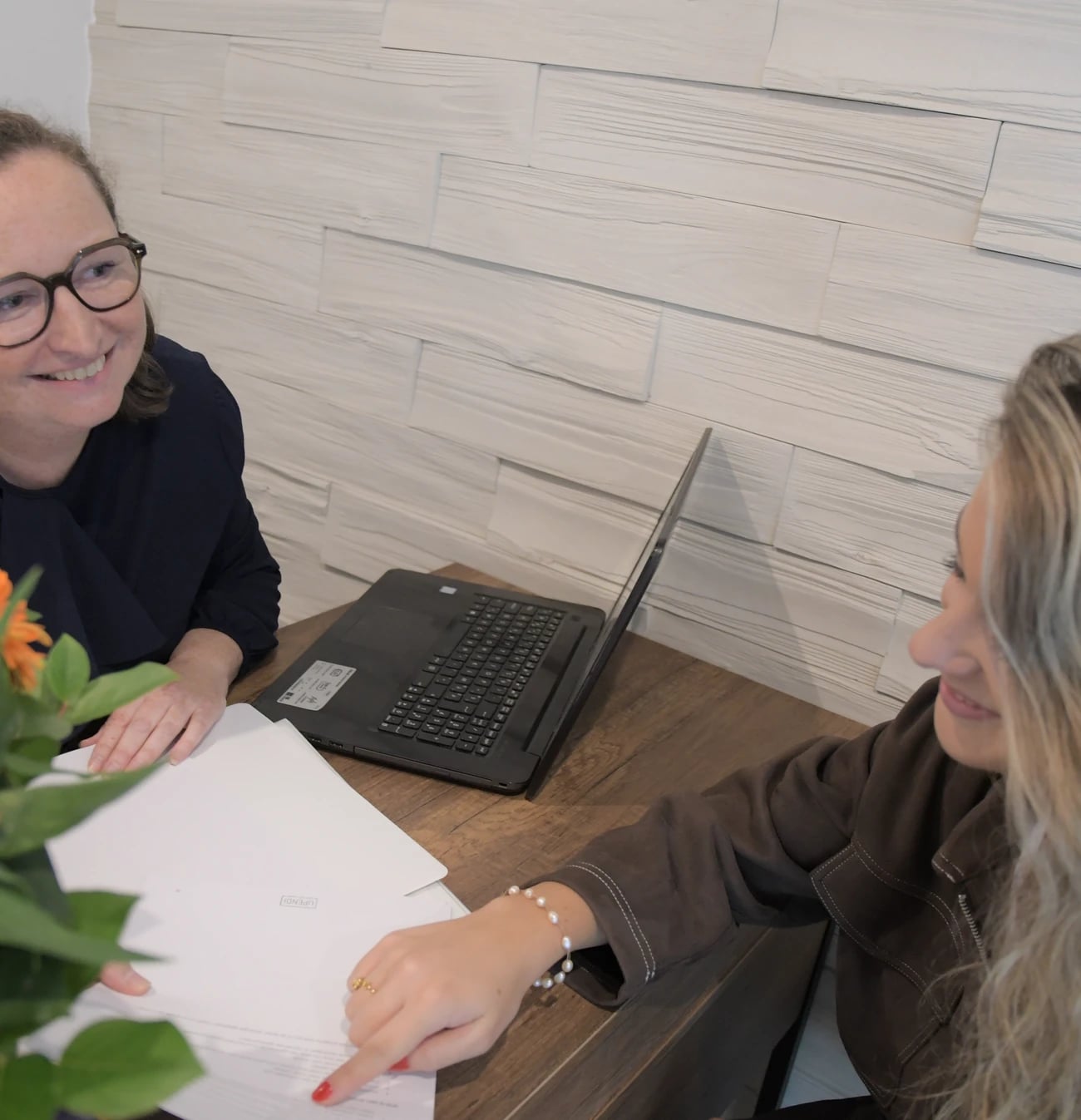 Elfriede en een coachee overlopen samen een document aan het bureau